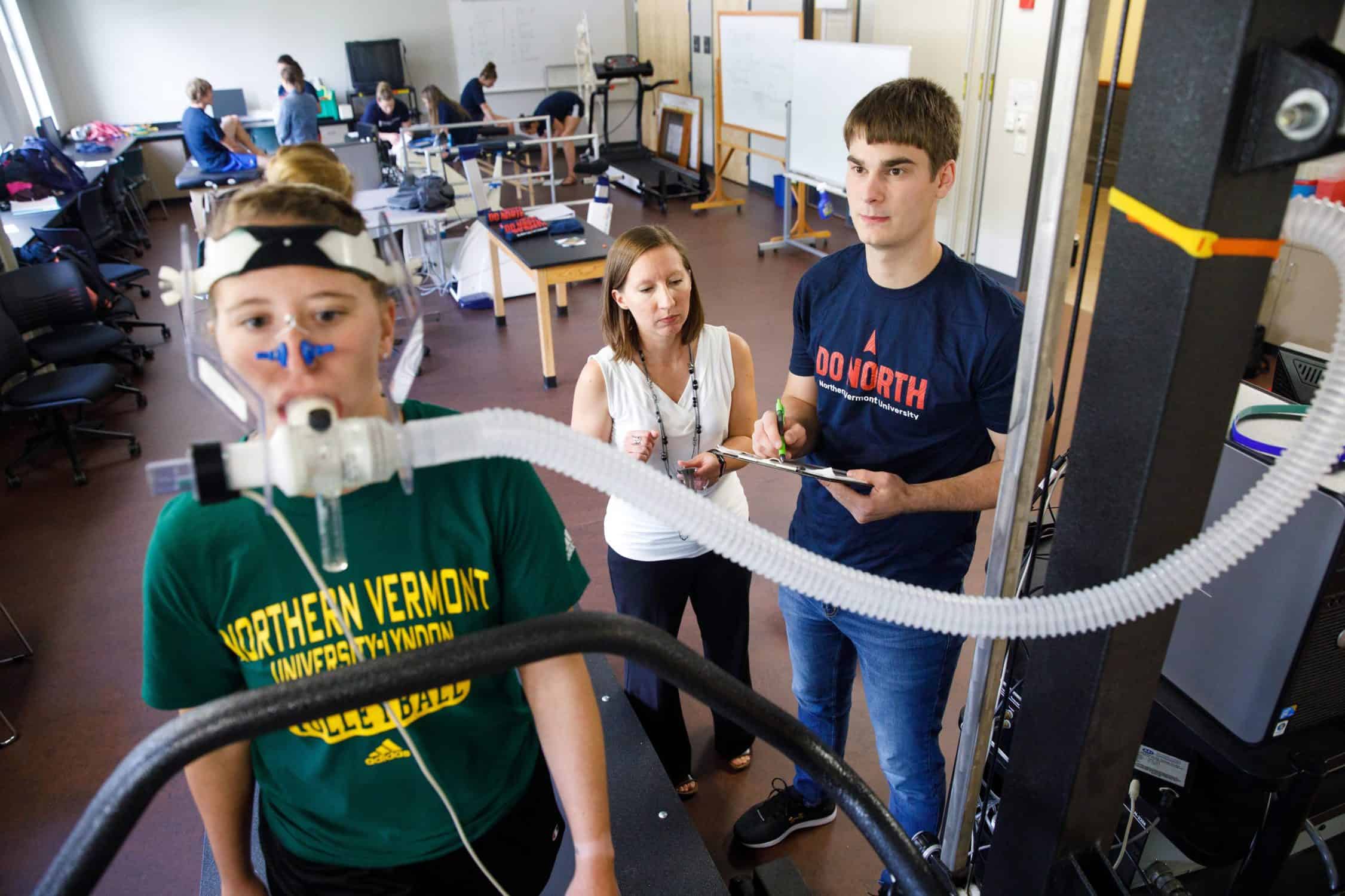 Student has their performance measured while jogging on a treadmill with special equipment