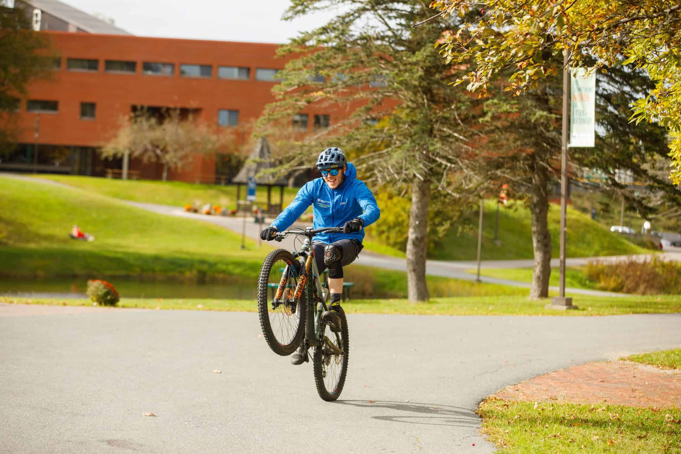 Student rides his bike through campus