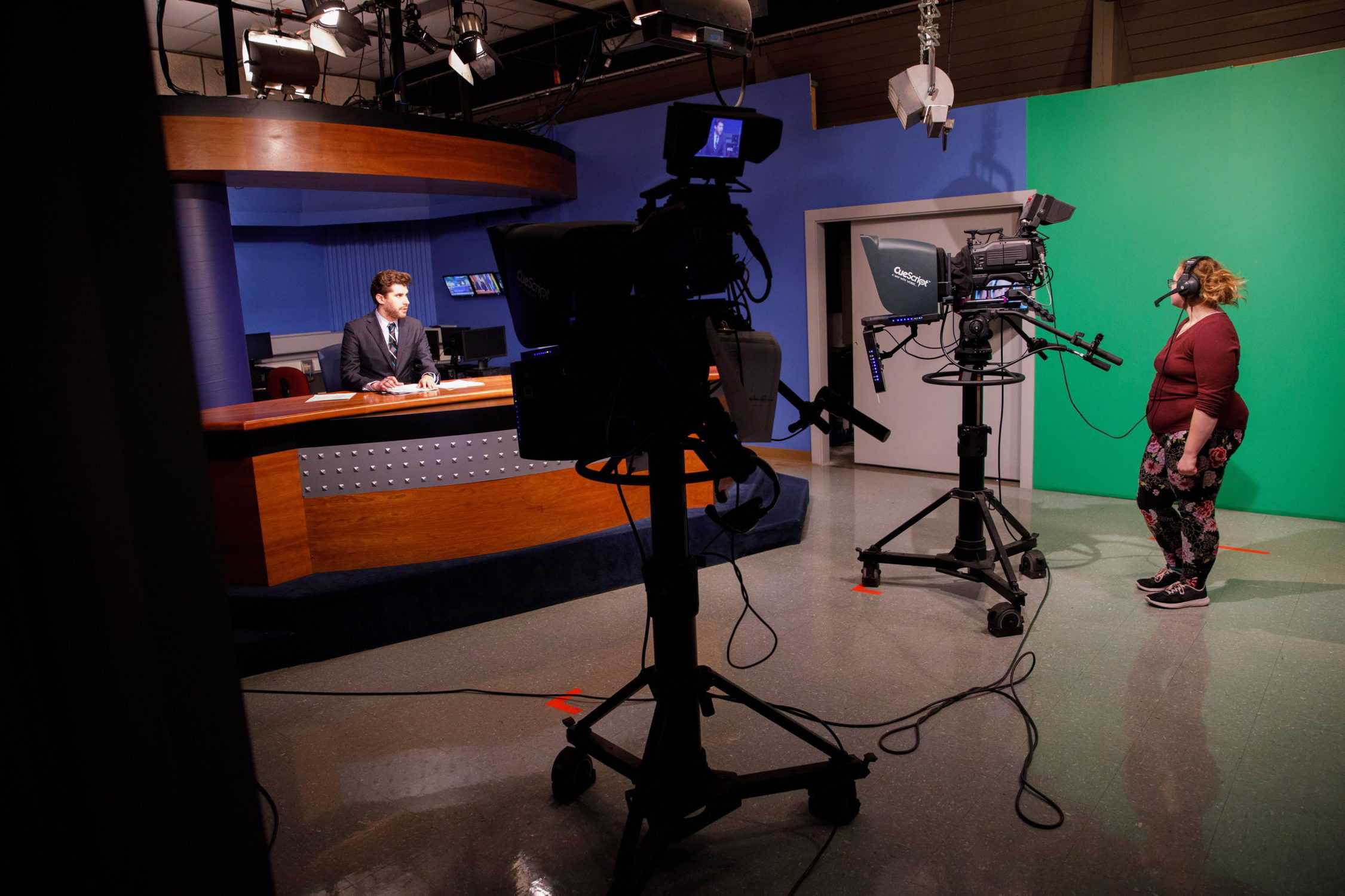 Student operates cameras in the news studio