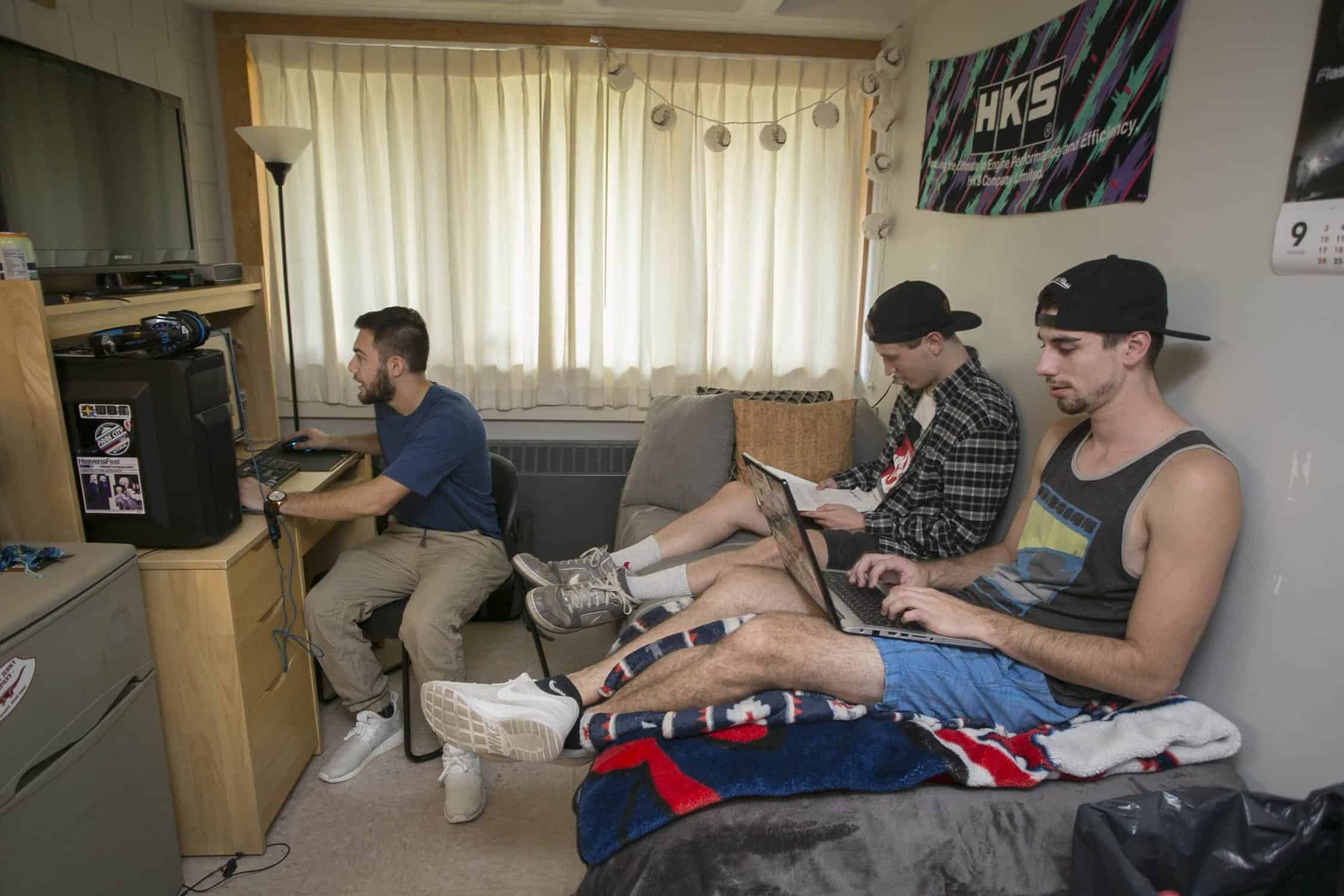 Three students study in a residence hall room