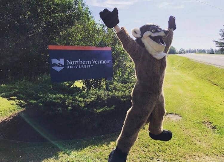 Johnson Badger Mascot jumps in front of campus sign