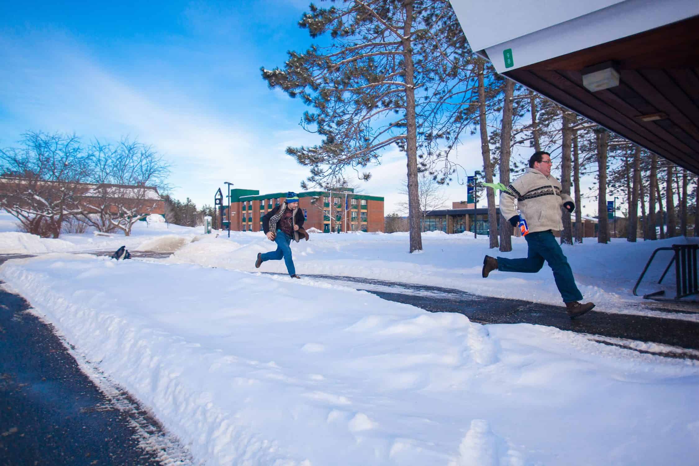 Students chase each other in the snow