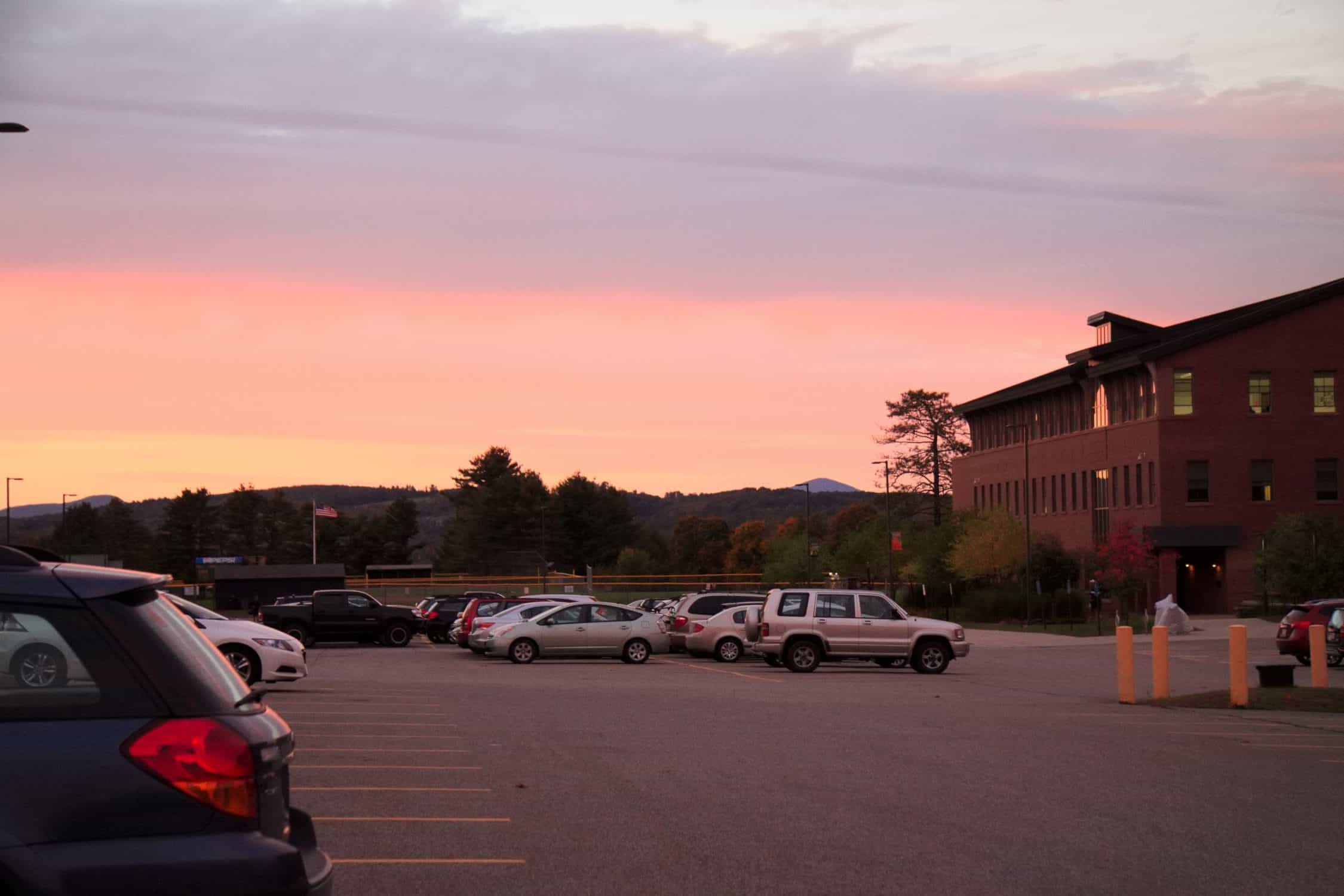 The sun sets over the parking lot outside the main entrance